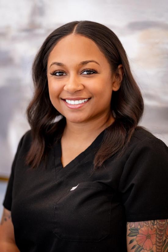 a woman in a black scrub top is smiling for the camera