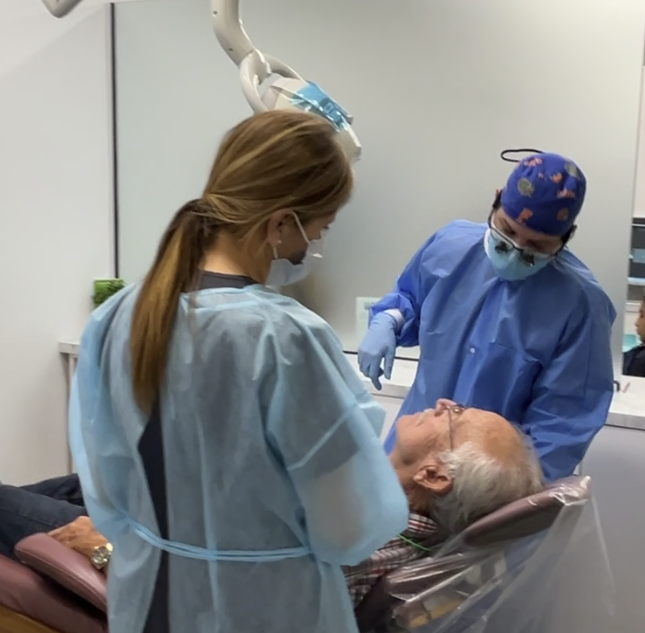 a dentist examines a patient 's teeth in a dental office