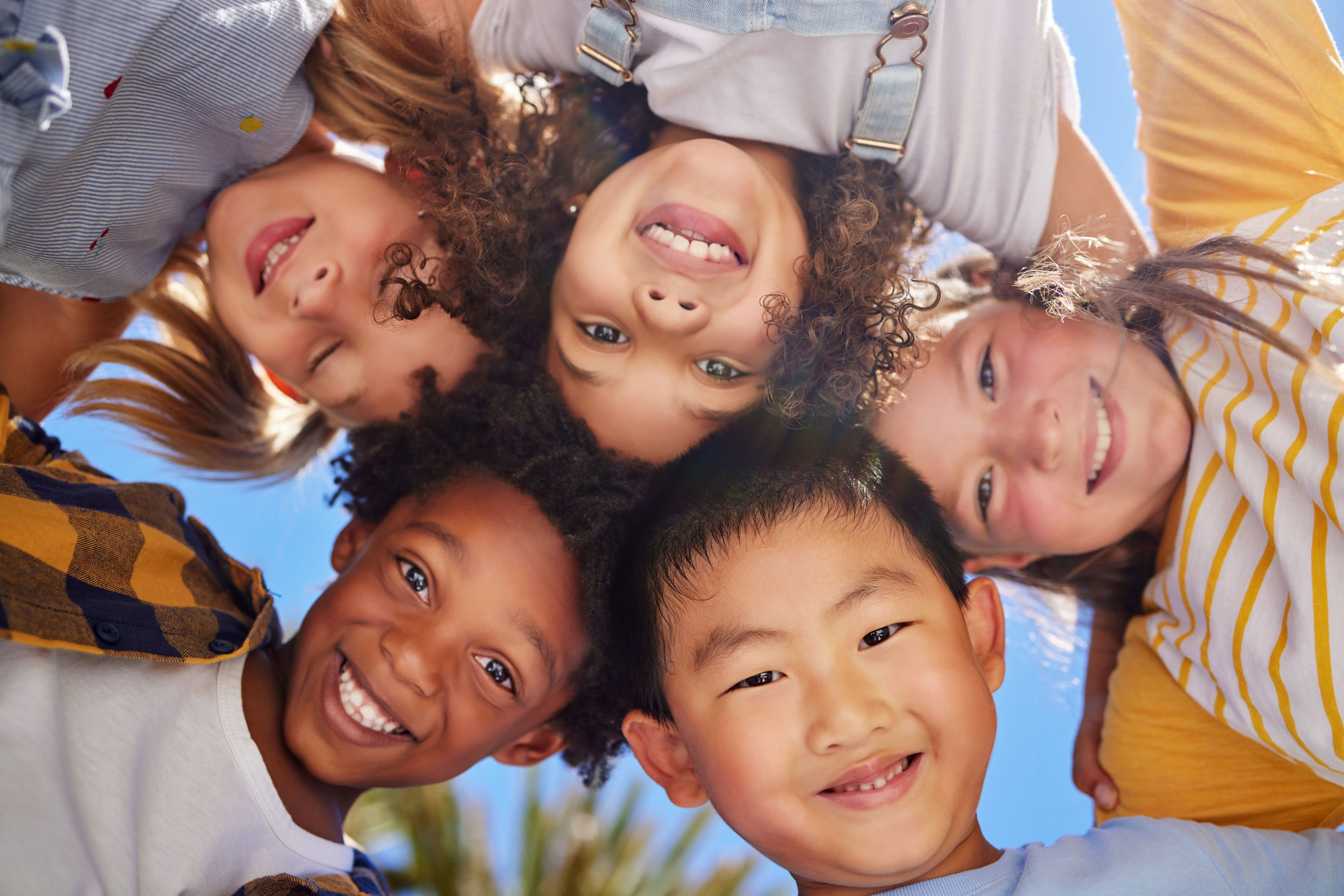 a group of children are standing in a circle and smiling at the camera .