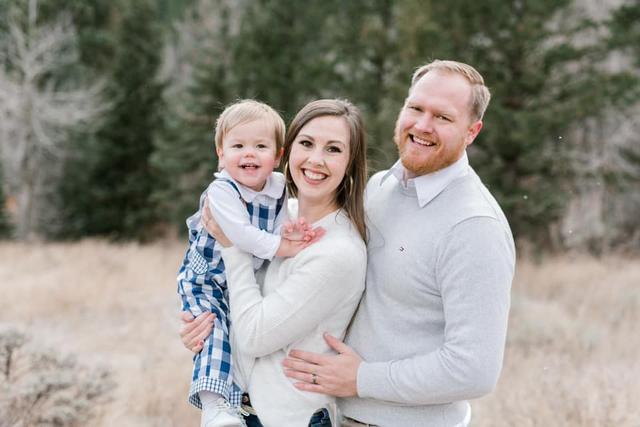a family is posing for a picture in a field .