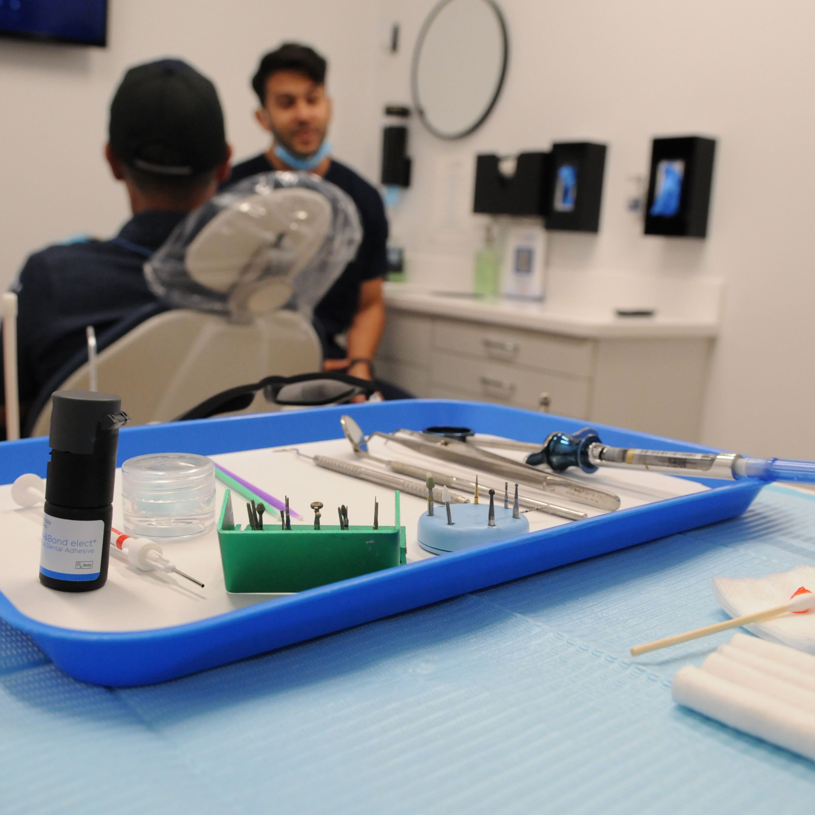 a tray of dental instruments is on a table in a dental office .