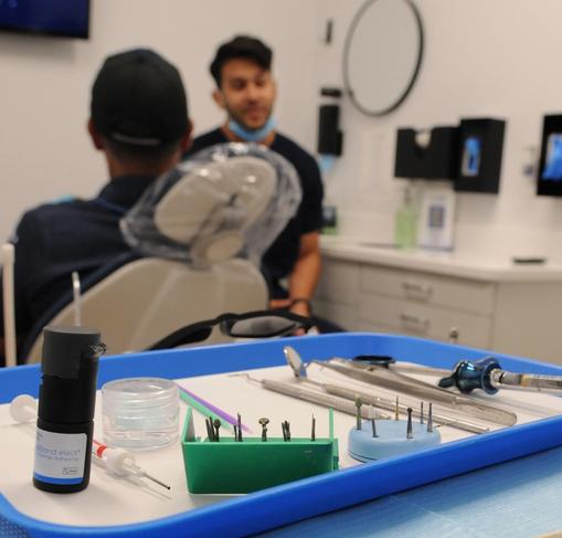 a blue tray filled with dental instruments is on a table in a dental office .