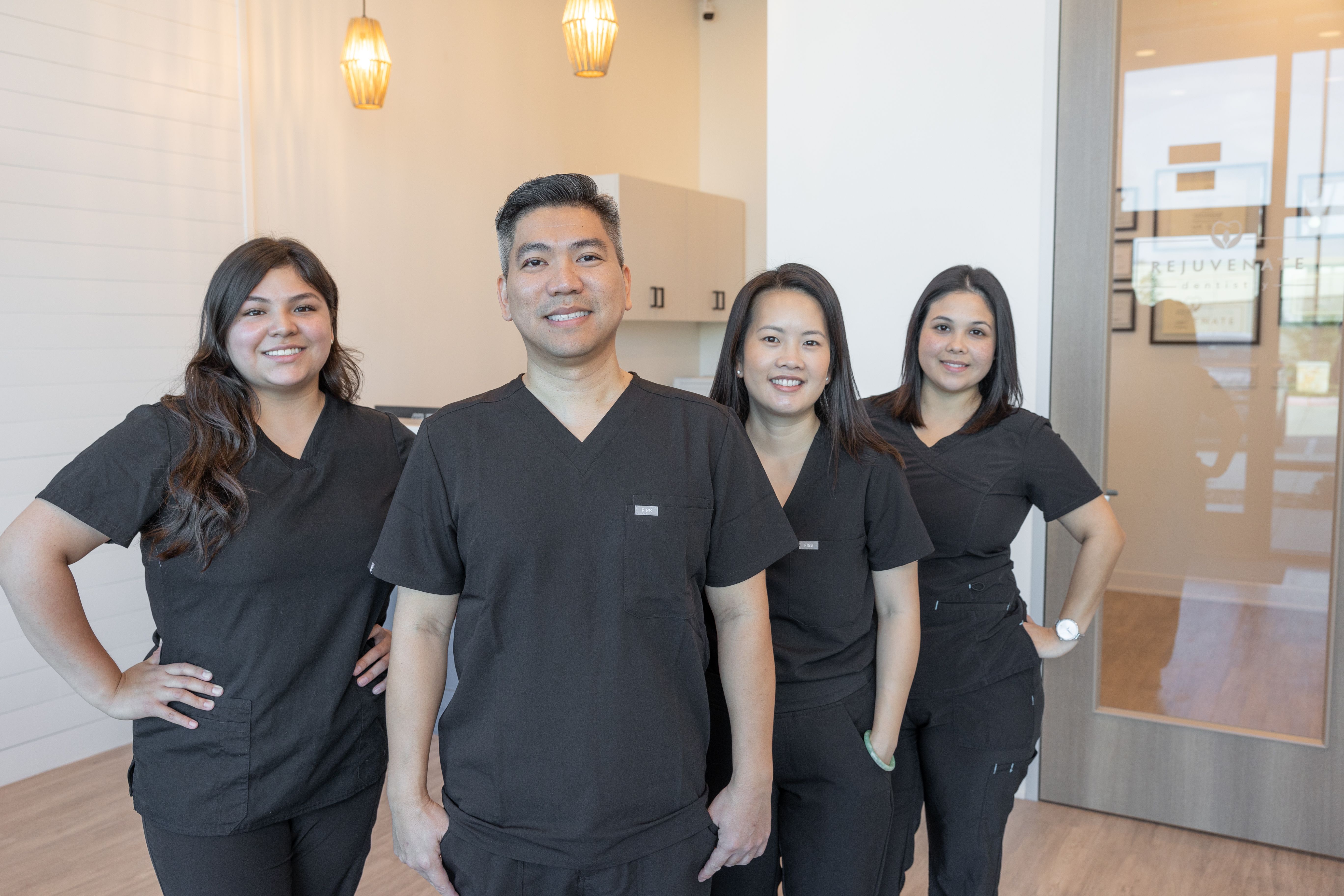 a group of dentists are posing for a picture in a dental office .