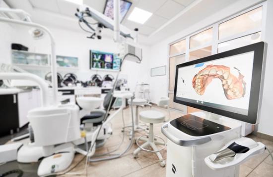 a dental office with a computer monitor showing a picture of a patient 's teeth .