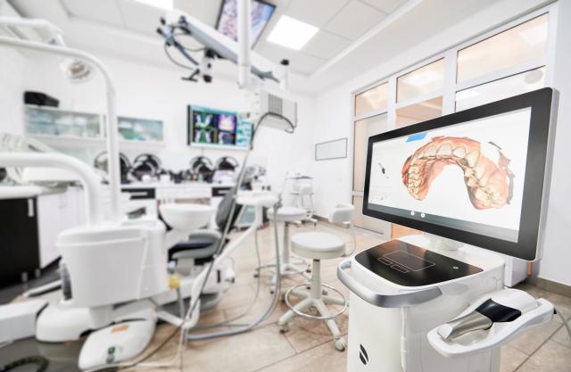 a dental office with a computer monitor showing a picture of a patient 's teeth .
