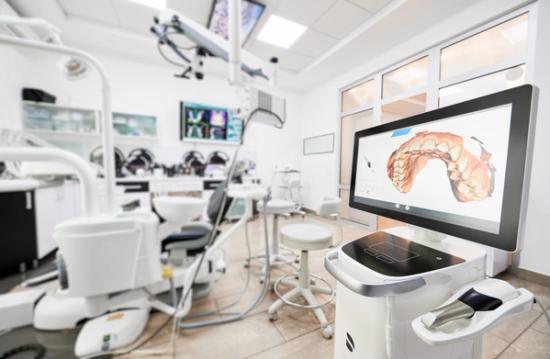 a dental office with a computer monitor showing a picture of a patient 's teeth .