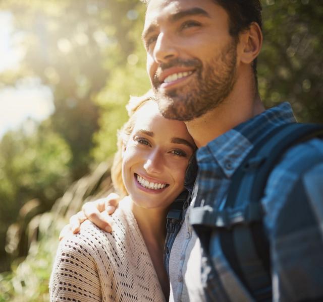 a man and a woman are standing next to each other and smiling .