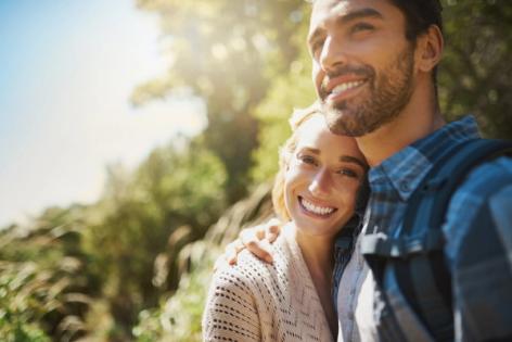 a man and a woman are standing next to each other and smiling .