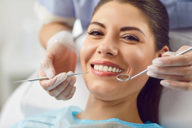 a woman is getting her teeth examined by a dentist .