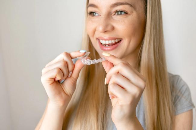 a woman is holding a clear brace in her hands .