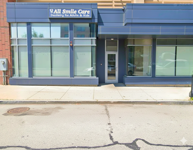 Exterior of "All Smile Care - Dentistry for Adults & Kids," a blue-gray building with large windows.