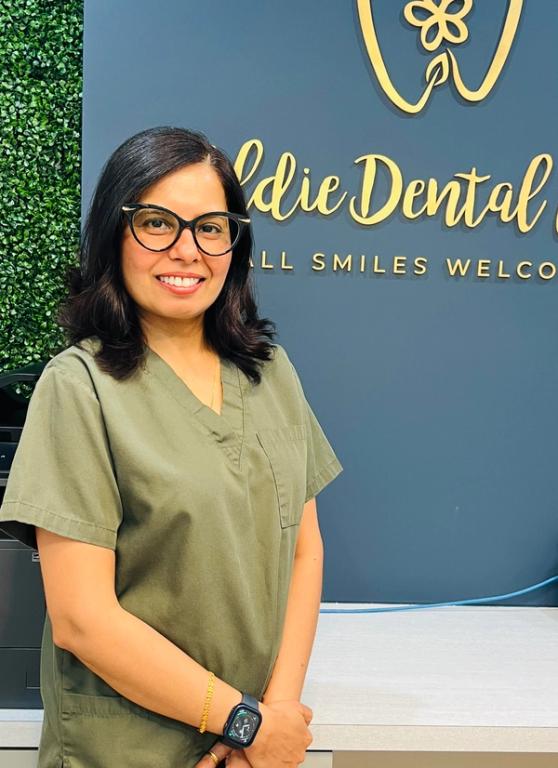 a woman stands in front of a sign that says dental care