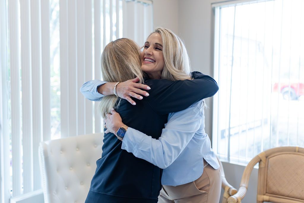 Two women hugging, one smiling happily.