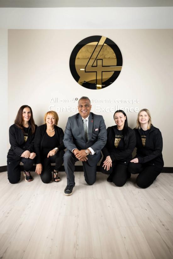 a group of people posing in front of a sign that says " all on 4 "