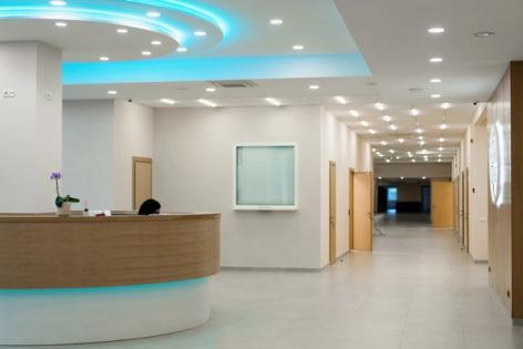 a hospital lobby with a reception desk and a blue light on the ceiling .