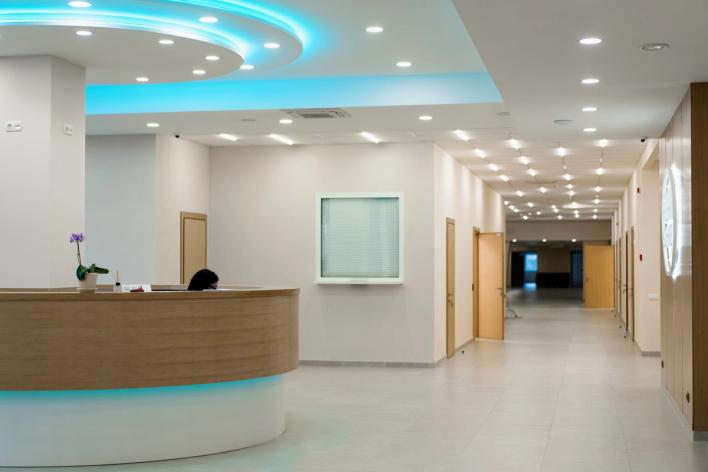 a hospital lobby with a reception desk and a blue light on the ceiling .