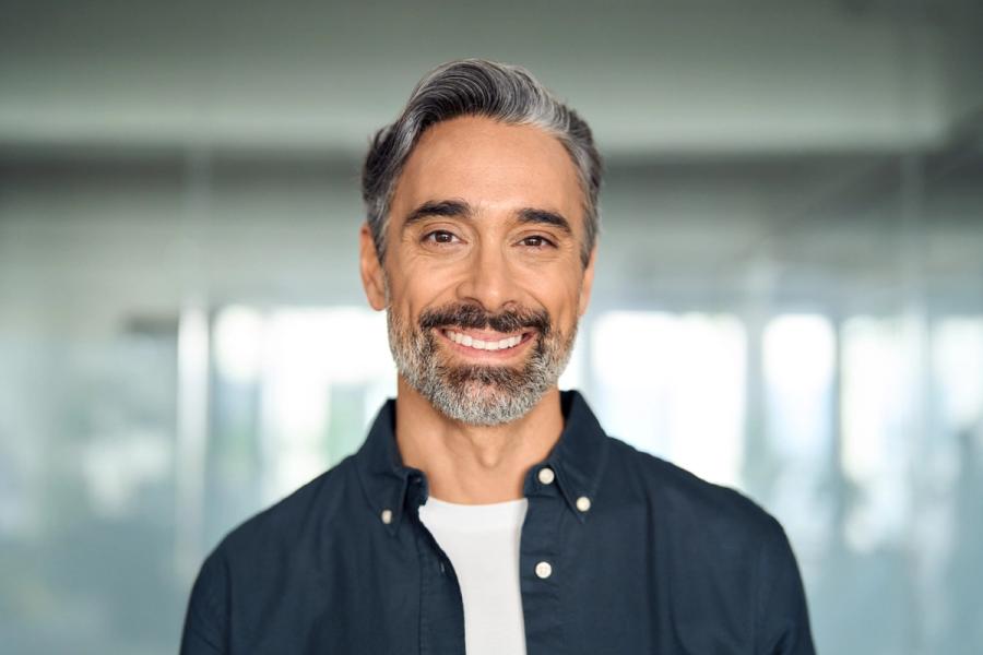 a man with a beard is smiling for the camera .