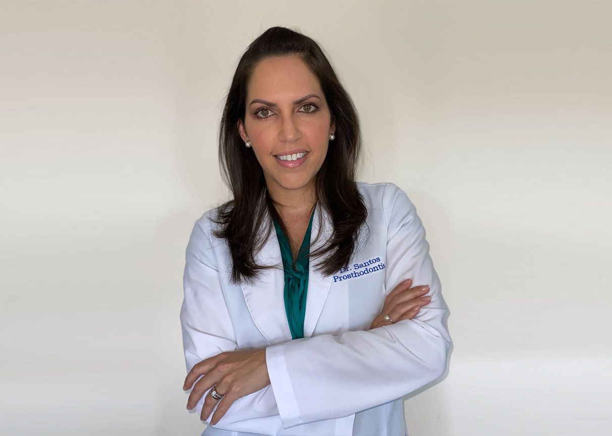 a woman is wearing a white lab coat and a green shirt .