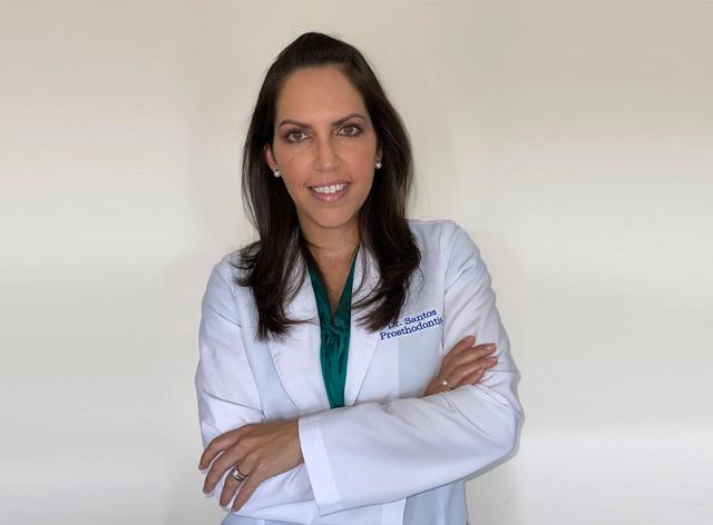 a woman is wearing a white lab coat and a green shirt .