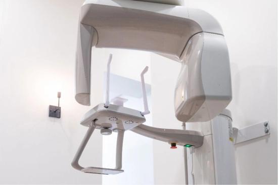 a dental x-ray machine is hanging on a wall in a dental office .