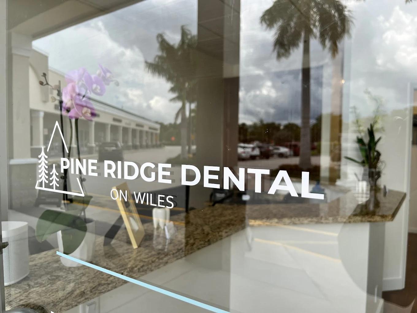the logo for pine ridge dental on wiles is on the glass door of a dental office .