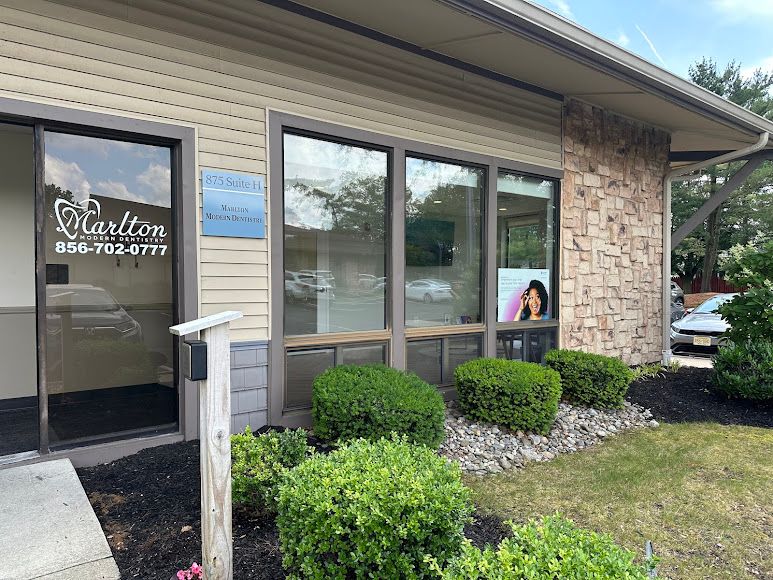 Exterior view of Marlton Modern Dentistry office with its entrance, windows, and business signage.