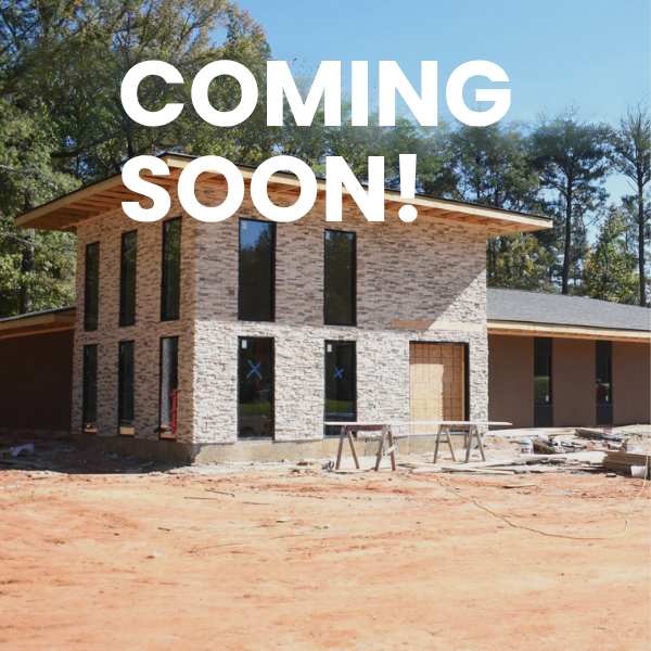 A stone-faced building under construction with "COMING SOON!" text.