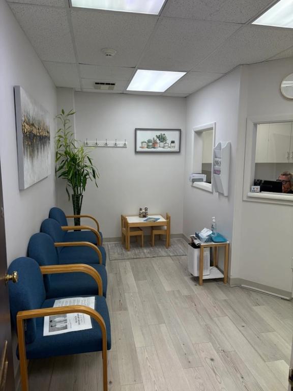 a waiting room with blue chairs and a small table