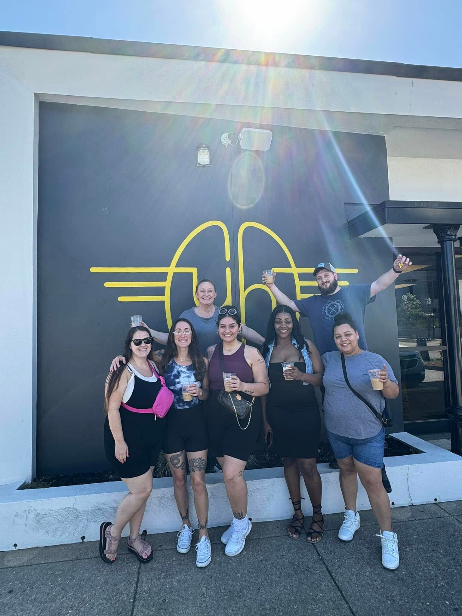 a group of people standing in front of a building with the letter a on it