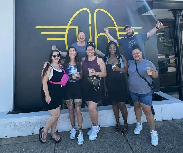 a group of people standing in front of a building with the letter a on it
