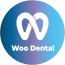 A blue book on a wooden table displays three circular "Woo Dental" stickers.