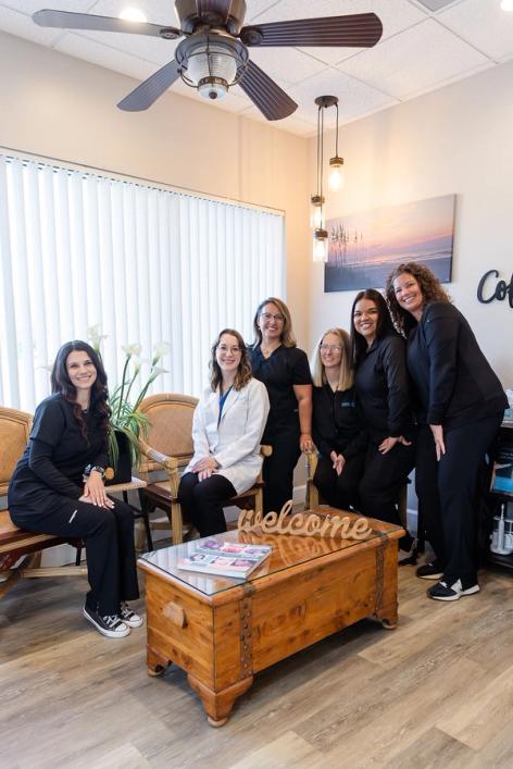 a group of women are posing for a picture in a waiting room .
