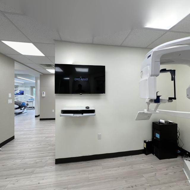 a dental office with a large flat screen tv mounted on the wall .