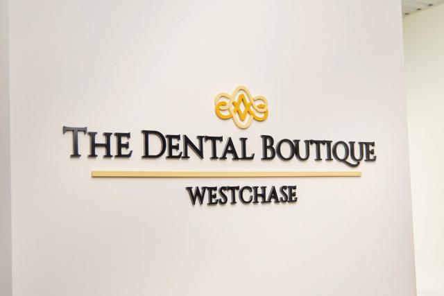a sign for the dental boutique is on a white wall .