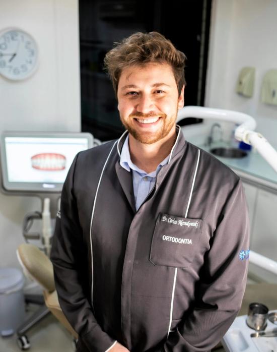 a man in a dental office with a name tag that says orthodontia