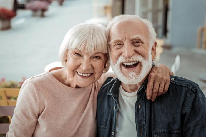 a man and a woman are laughing together and posing for a picture .