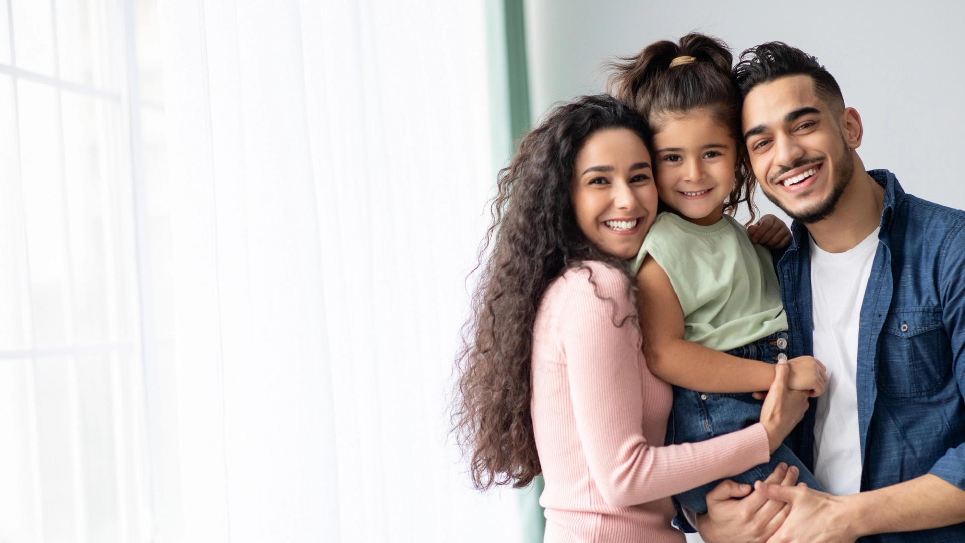 a man and woman are holding a little girl in their arms