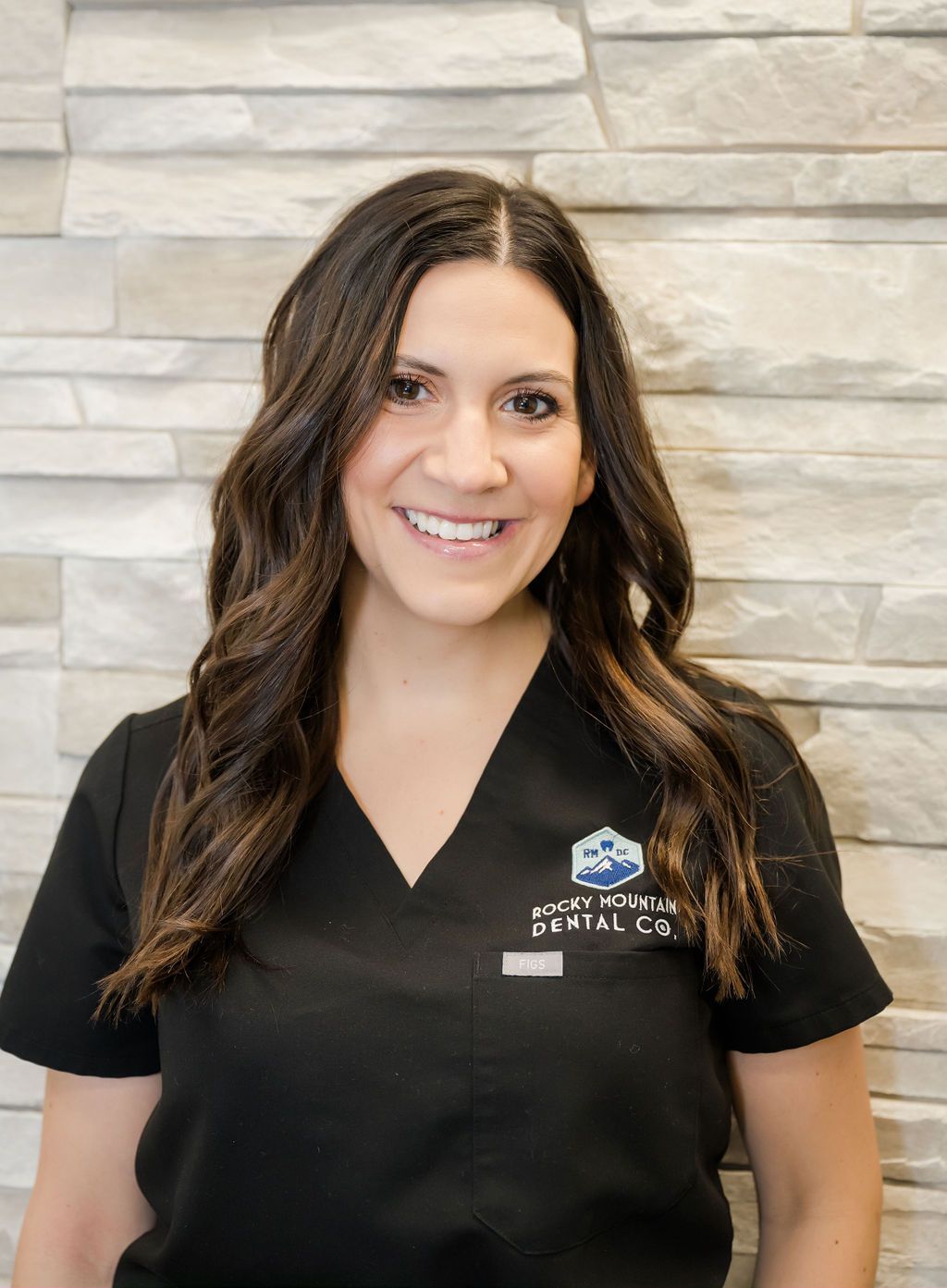 a woman wearing a rocky mountain dental co. scrub top