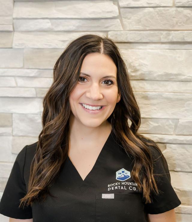 a woman wearing a rocky mountain dental co. scrub top
