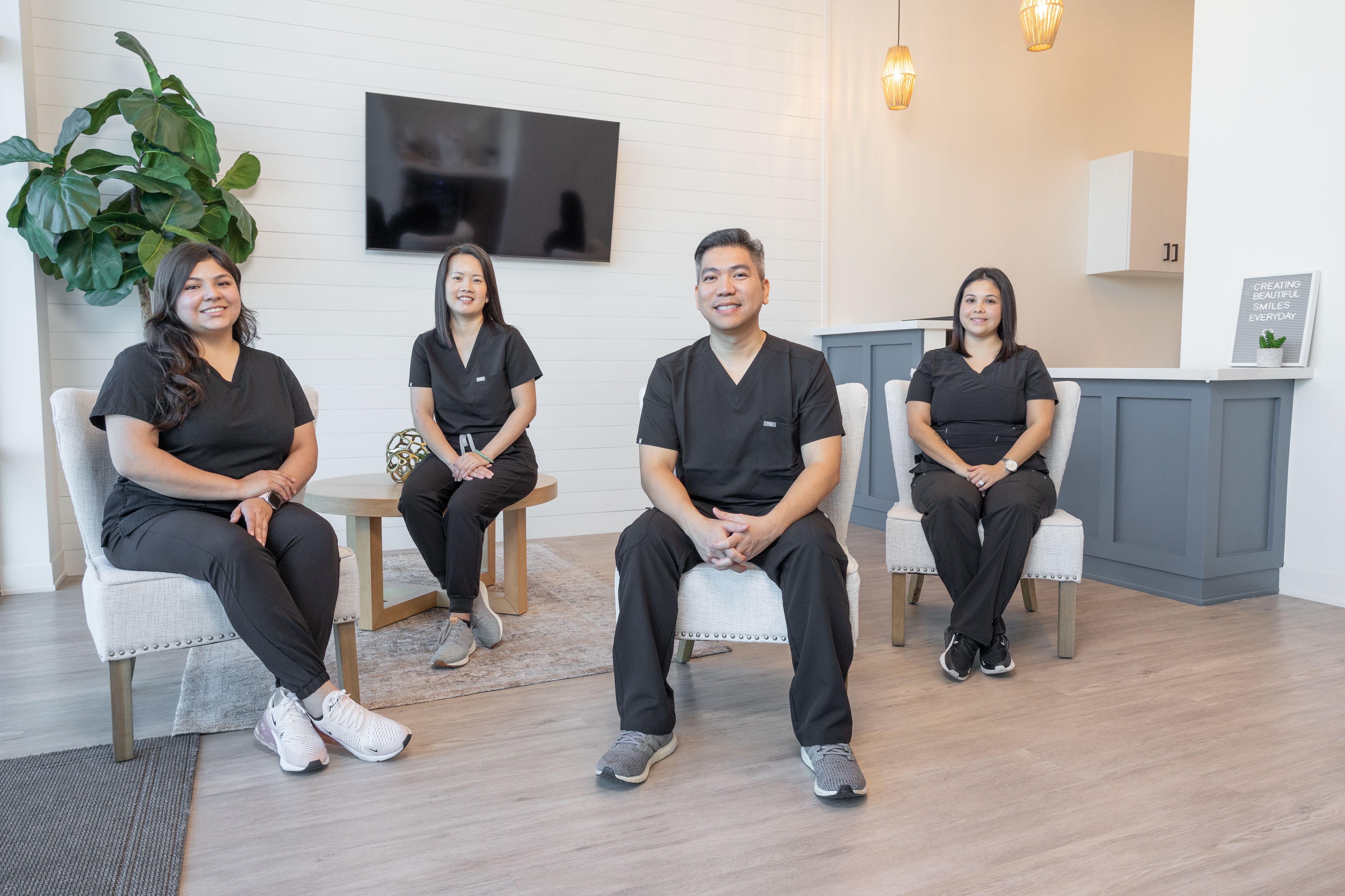 a group of dentists are sitting in chairs in a waiting room .