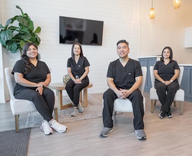 a group of dentists are sitting in chairs in a waiting room .