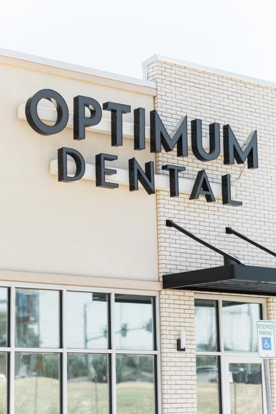 a brick building with a sign that says optimum dental