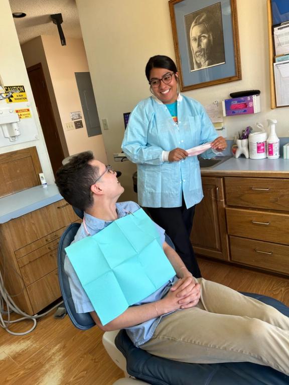 a man in a dental chair talking to a female dentist