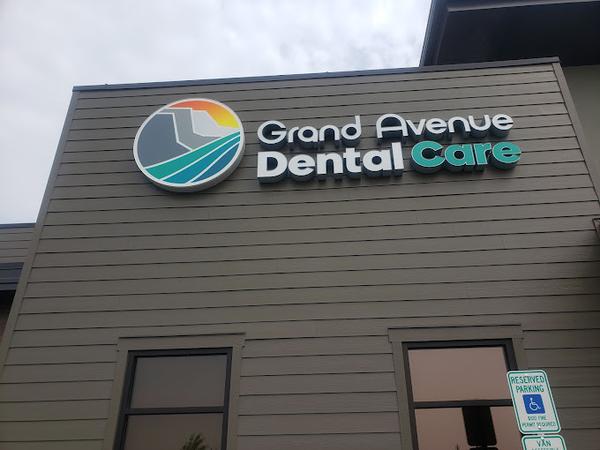 a sign for grand avenue dental care is on the side of a building .