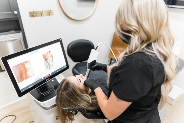 a woman is getting her teeth examined by a dentist in a dental office .