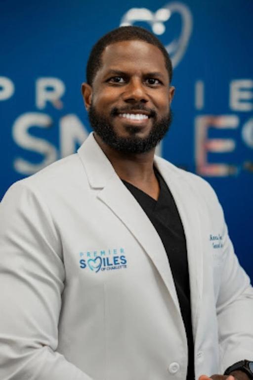 a man wearing a white lab coat that says premier smiles on it
