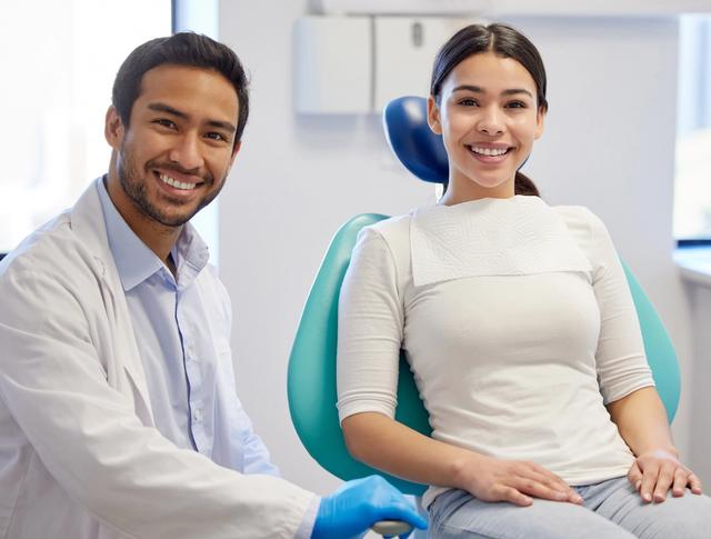 a woman is sitting in a dental chair next to a dentist .
