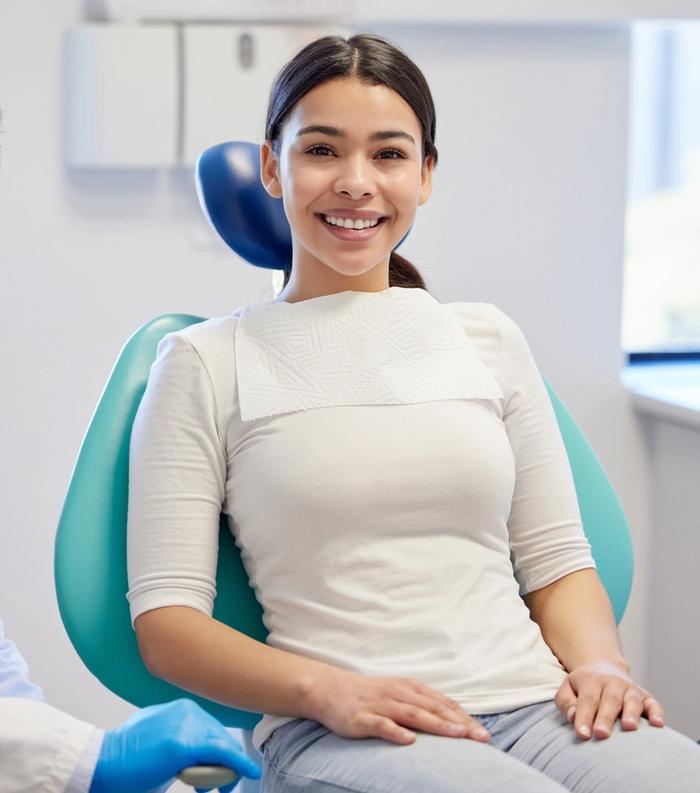 a woman is sitting in a dental chair next to a dentist .