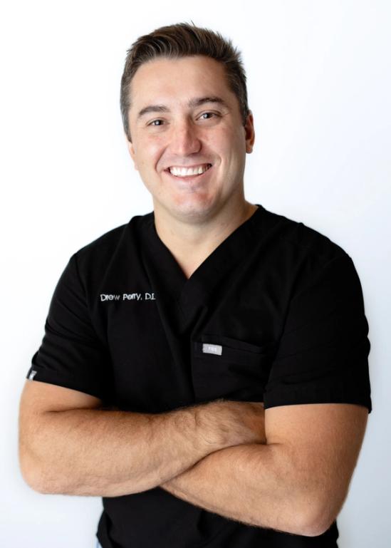 a man wearing a black scrub top with the name drew poppy on it