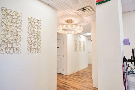 a hallway in a dental office with a chandelier hanging from the ceiling .